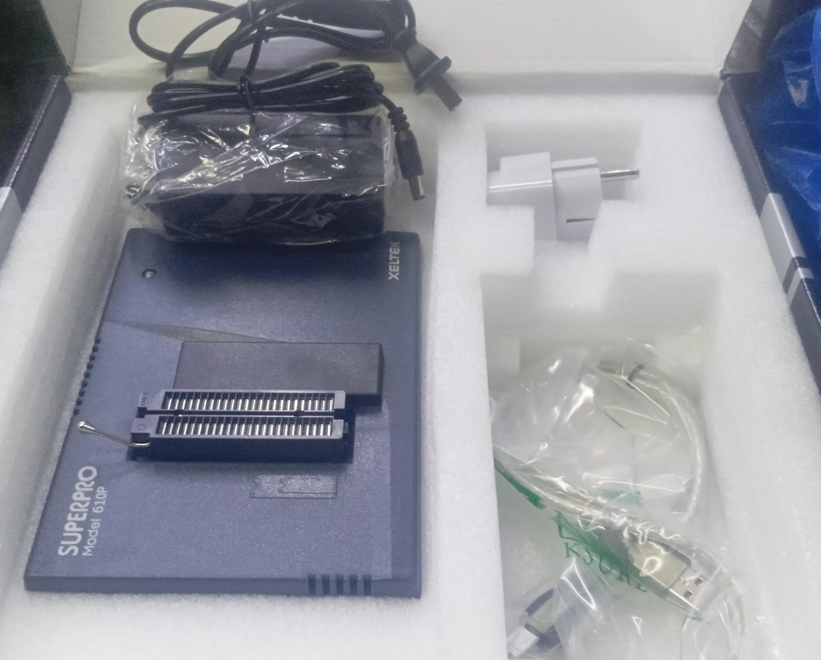 SUPERPRO 610P Universal Programmer | High-Speed IC Programming - shown in its box with a power adapter, a plug converter, and a USB cable.