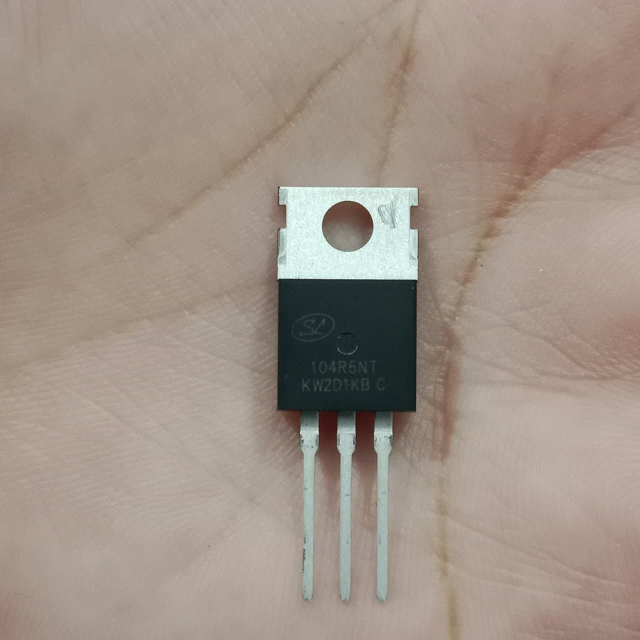 SVG104R5NT N-Channel Power MOSFET - a black three-pin electronic component with a metal heat sink tab, held against a human palm.