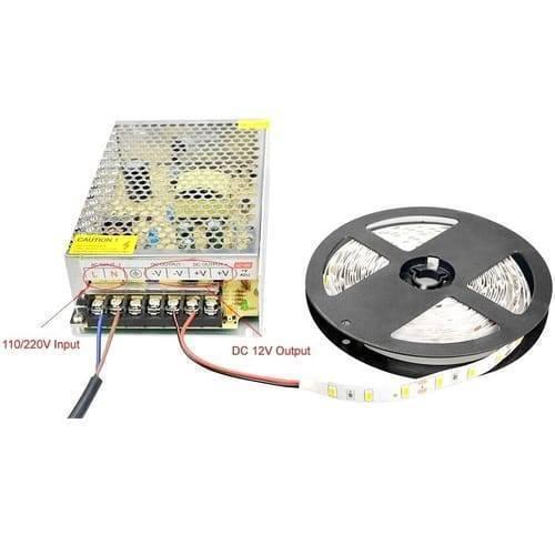 Switching DC Power Supply SMPS 12V 20A 240W - shown with a metal mesh casing, screw terminal input/output ports, and a connected roll of LED strip lights.