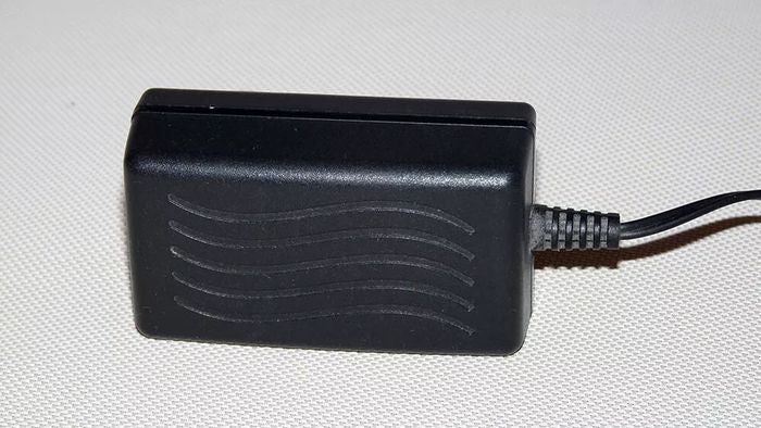 Switching Power Supply Adapter S012BU2400050 24V 400mA - a black, rectangular power adapter with a wavy-line texture and an attached power cord.