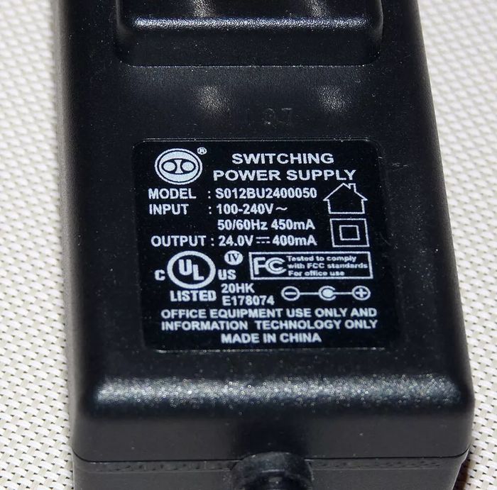 Switching Power Supply Adapter S012BU2400050 24V 400mA - a close-up of the black rectangular power brick showing its technical specifications label.