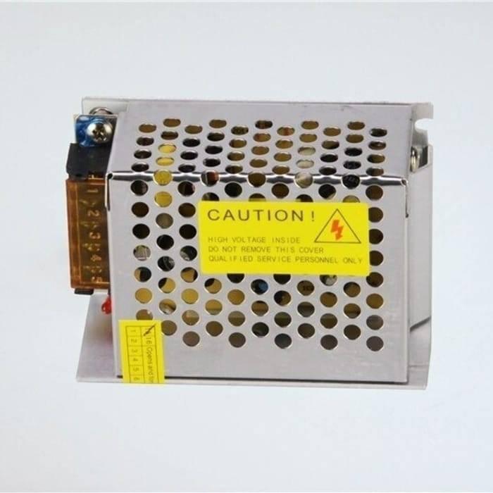Switching Power Supply SMPS 12V 5A - shown as a silver metal-cased unit with a perforated cover, a yellow caution label, and a side terminal block.
