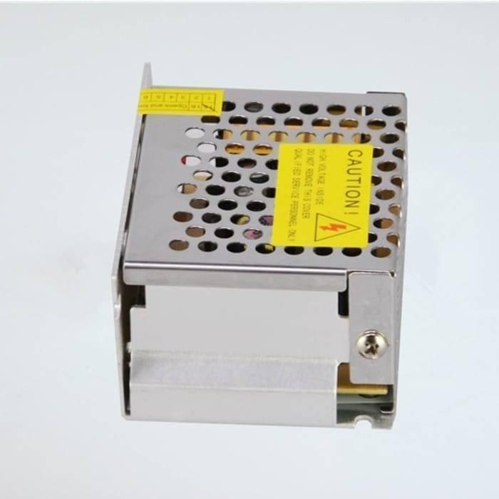 Switching Power Supply SMPS 12V 5A - shown as a metallic, perforated rectangular unit with a yellow caution label and a numbered terminal block strip.
