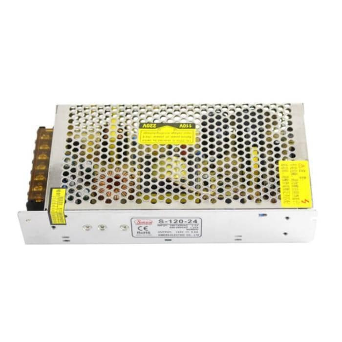 Switching Power Supply SMPS 24V 5A - shown as a silver, rectangular metal unit with a perforated mesh cover, a terminal block on the side, and labels.