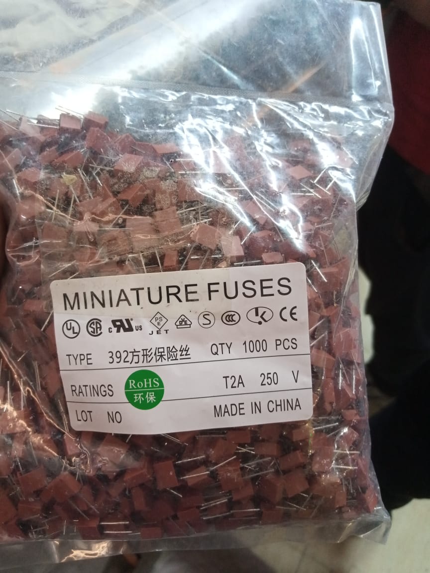 T2A250V PCB Mount 2A Miniature Fuse - shown as a bulk pack of 1000 brown, square-shaped radial fuses inside a clear plastic bag with a product label.