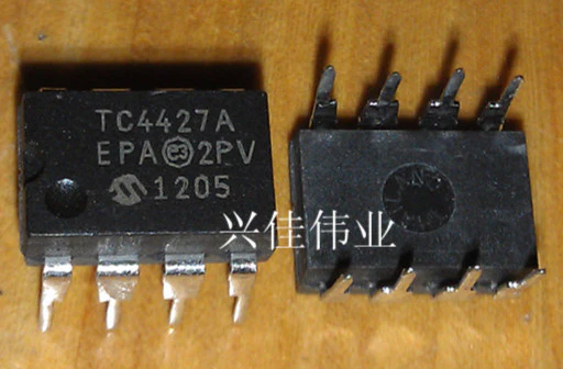 TC4427A Dual High-Speed MOSFET Driver IC - two black 8-pin DIP integrated circuit chips with white text markings on a wooden surface.