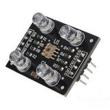 TCS3200 Color Sensor Module - a black circuit board with four LEDs, a central sensor chip, and a row of eight output pins.