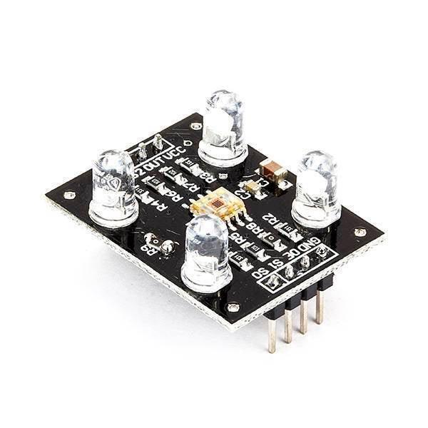 TCS3200 Color Sensor Module - a black rectangular circuit board with four white LEDs, a central sensor chip, and a row of eight output pins.