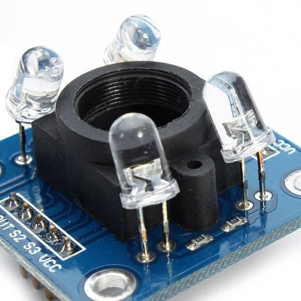 TCS3200 Color Sensor Module With Cap - close-up showing the blue circuit board with four LEDs surrounding a central black sensor housing and pin headers.