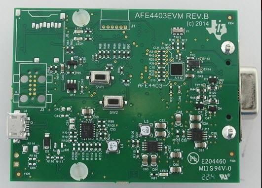 Texas Instruments Analogue Front End Heart Rate Sensor Evaluation Kit For AFE4403 - a green rectangular printed circuit board featuring a micro-USB port, two push buttons, and a serial connector.