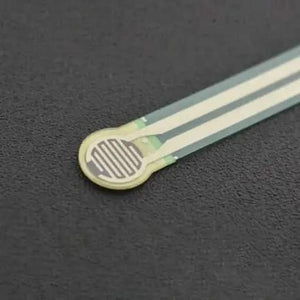 Thin Film Pressure Sensor FSR RP-C7.6-LT-LF2 Flexible High Sensitivity 30G to 8KG - a close-up of the flexible, circular-headed sensor with a white interdigitated pattern on a dark surface.