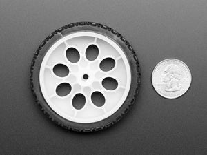 Thin White Wheel for TT DC Gear Motors - 65mm Diameter - a white plastic wheel with a black rubber tire next to a US quarter dollar coin.