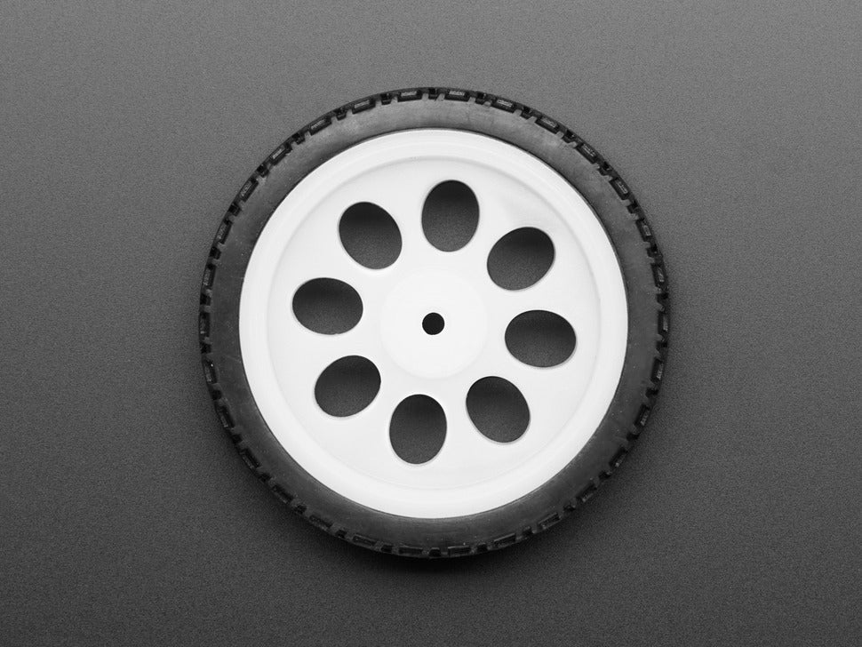 Thin White Wheel for TT DC Gear Motors - 65mm Diameter - a top-down view of a white plastic wheel with a black rubber tire on a grey background.