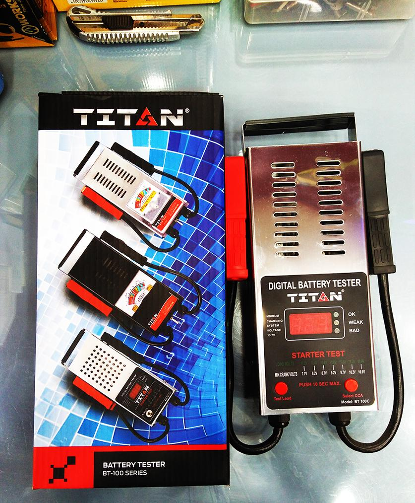 TITAN BT-100C Digital Battery Tester - shown with its silver metal housing, red and black clamps, digital display, and its original branded retail box.