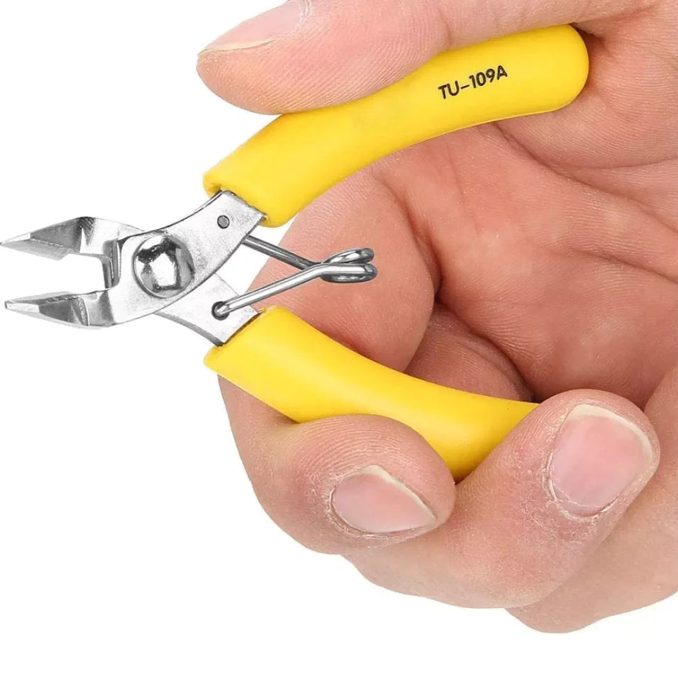Tni-u TU-109A Wire Cutter - shown in a hand, featuring yellow handles, a metal cutting head, and a spring-loaded mechanism.