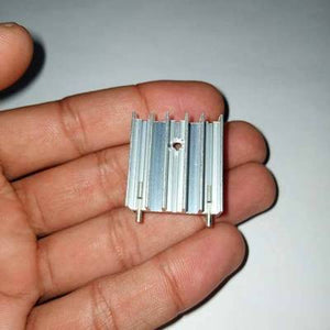 TO3P Black And Silver Heat Sink - a silver-colored aluminum heatsink with vertical fins and two mounting pins held in a hand.