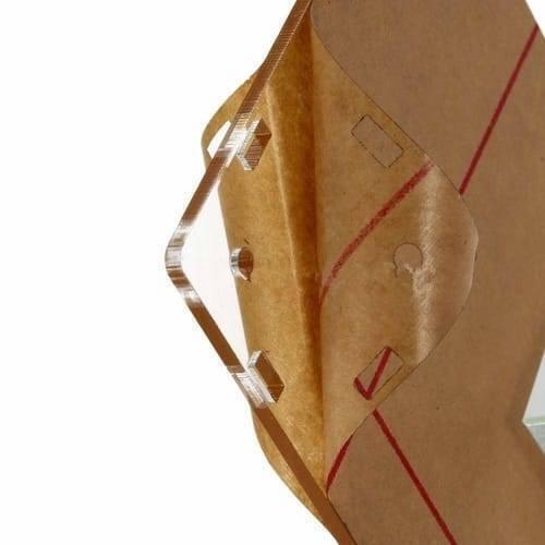 Transparent Acrylic Case Housing Module For DSO138 2.4 Inch TFT Digital Oscilloscope Anti Scratch Protection Shell DIY Kit - close-up view of a clear acrylic panel with cutouts, partially covered by a brown protective film.