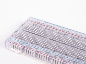 Transparent Clear Breadboard 830 Tie-Points with 4 Sets of Power Rails - a close-up angled view of the clear plastic grid and labeled terminals.