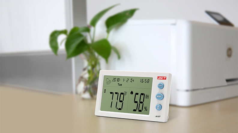 UNI-T A13T Digital Temperature & Humidity Meter – Indoor Hygrometer Thermometer, Comfort Level, Clock, Calendar, ℃/℉ - a white rectangular device showing 77.9°F and 58% RH on its display with three buttons on the side.