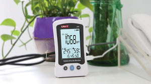 UNI-T A37 CO2 Meter – 400–5000 PPM Carbon Dioxide, Temperature, NDIR Air Quality Monitor, Rechargeable - a white handheld monitor showing 1068 ppm, 24.5°C, 59% RH, and 15:45:50 on its display, connected to a charging cable.