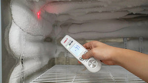 UNI-T A63 2-in-1 Food Thermometer – Infrared + Fold-Out Probe, -40 to 300℃, Laser Targeting, Kitchen / BBQ Cooking Thermometer - held in a hand inside a frosted freezer, showing a digital display reading -77 and a red laser dot on the ice.