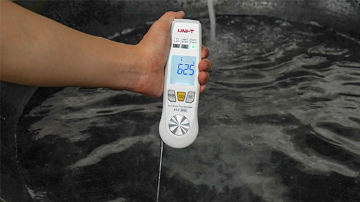UNI-T A63 2-in-1 Food Thermometer – Infrared + Fold-Out Probe, -40 to 300℃, Laser Targeting, Kitchen / BBQ Cooking Thermometer - a white handheld device with a fold-out probe, held over water with a digital display showing 625 degrees Celsius.