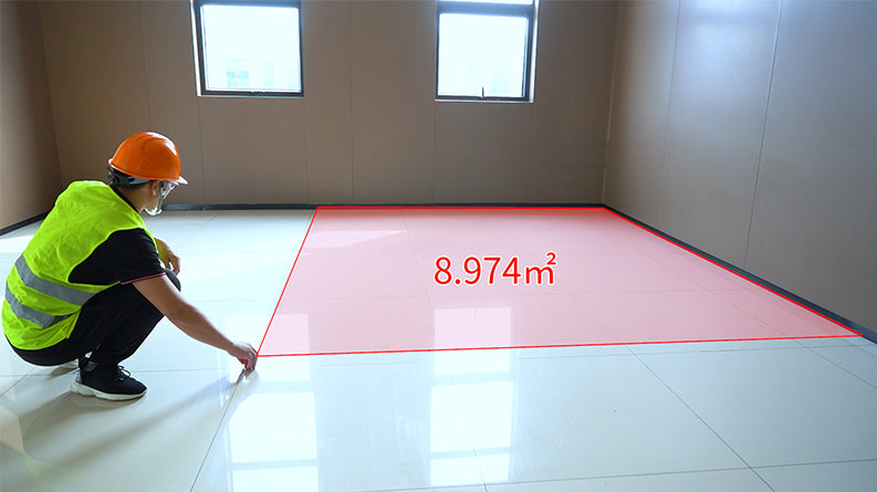 UNI-T LM50A Laser Distance Meter – 50 m, ±2 mm, Area / Volume / Pythagorean, 99 Memory, 2.0" LCD, Bubble Level, Laser Measure Tape - being used by a worker to measure a floor area, with a red digital overlay showing 8.974m² on the tiled surface.