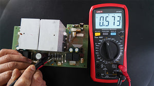 UNI-T UT107+ True RMS Automotive Multimeter – 6000 Count, RPM, Dwell Angle, Pulse Width, Battery Test, Temperature, 1000V AC/DC, VFC, CAT III 600V - with a red casing and black rotary dial, showing a 0.573V reading while testing a circuit board with probes.