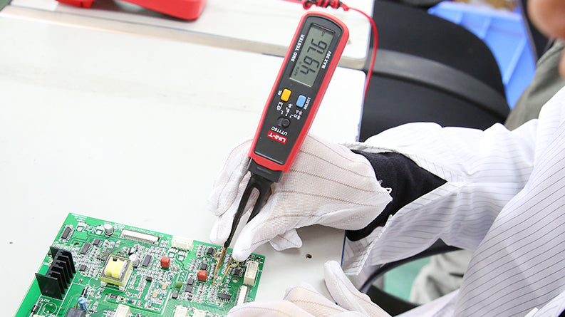 UNI-T UT116A SMD Tester – Tweezer Component Tester, Auto-Identify Resistance, Capacitance, Diode, LED/Zener, 3000 Count, 180° Rotating Pen - a red handheld tweezer-style device with a digital display showing 497.6, held by a gloved hand testing a green circuit board.