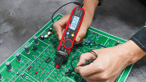 UNI-T UT118C True RMS Pen Type Digital Multimeter – AC/DC 600V, Resistance, Capacitance, NCV, Gold-Plated Tips, CAT III 600V / CAT IV 300V - held by hands testing a green circuit board, with the digital display showing 0.622.
