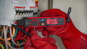 UNI-T UT118C True RMS Pen Type Digital Multimeter – AC/DC 600V, Resistance, Capacitance, NCV, Gold-Plated Tips, CAT III 600V / CAT IV 300V - held by a gloved hand, showing a red-and-black body with a digital display reading 380.4 and a black test lead.