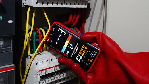 UNI-T UT121B Smart Digital Multimeter – 6000 Count Auto-Identify, True RMS, Dual Display EBTN, AC/DC 600V, 60mF Capacitance, NCV, Live Wire, CAT III 600V - held in a red-gloved hand, showing an EF mode display with a bar graph and dashed lines near electrical wiring.