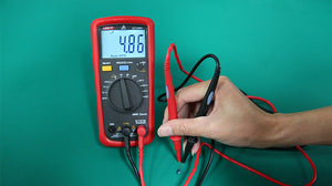 UNI-T UT133A Digital Multimeter – 6000 Count Auto-Range, AC/DC Voltage & Current, Capacitance, Frequency, Temperature, Over-Voltage Alarm, 2m Drop-Proof - with a red protective case, showing a 4.86 reading on the screen while probes measure a small electronic component.