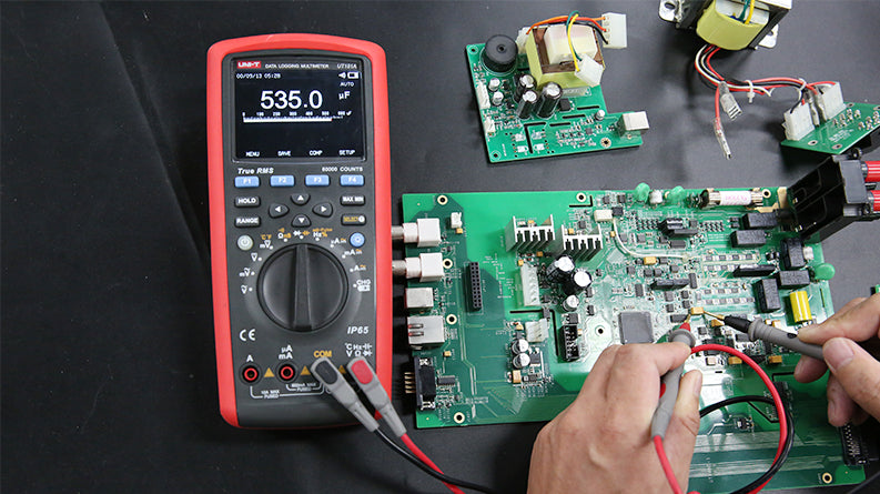 UNI-T UT181A Datalogging True RMS Digital Multimeter – 60000 Count, 4.5" Color TFT, AC/DC 1000V, 10A, Data Logging, Temperature, USB, CAT III 1000V / CAT IV 600V - with a red casing, showing a 535.0 µF reading on its display while testing a green circuit board.