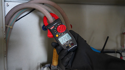 UNI-T UT2117R True RMS Digital Clamp Meter – 1000A AC, AC/DC 1000V, 60MΩ Resistance, Capacitance, Frequency, Dual-Mode NCV, 1000V Overload Protection, CAT III 600V / CAT II 1000V - held in a gloved hand, showing a red and black body with a rotary dial and a digital display reading 226.8.
