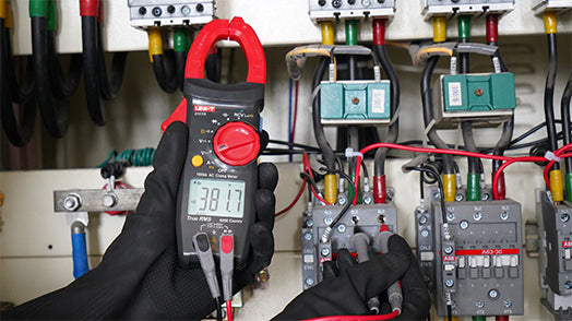 UNI-T UT2117R True RMS Digital Clamp Meter – 1000A AC, AC/DC 1000V, 60MΩ Resistance, Capacitance, Frequency, Dual-Mode NCV, 1000V Overload Protection, CAT III 600V / CAT II 1000V - held in a gloved hand, showing a red rotary dial, a digital display reading 381.7, and two connected test leads.