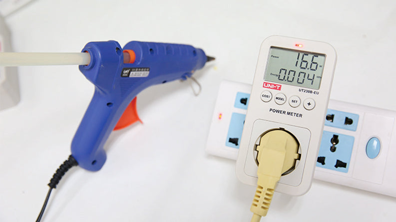 UNI-T UT230B-EU Plug-In Power Socket Energy Meter – Monitors Voltage, Current, Power, kWh, Cost & CO₂ for EU Schuko Outlets, 100–260V, 16A, Overload Alarm - a blue glue gun connected and a digital display reading 16.6W and 0.004kWh.