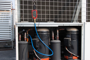 UNI-T UT336P KIT Wireless Digital Pressure Gauge with Temperature Clamp – -1 to 60 bar, HVAC Refrigerant Manifold, 94 Refrigerants, App Connected - red casing and screen showing 10.28, connected by a blue hose to an HVAC compressor unit.