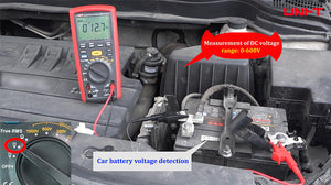 UNI-T UT505A Insulation Resistance Tester – Digital Megohmmeter - a red handheld device with a digital display showing 12.7V, connected to a car battery with test leads.