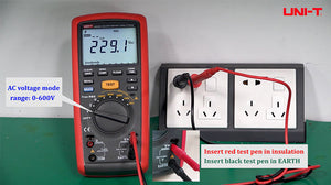 UNI-T UT505A Insulation Resistance Tester – Digital Megohmmeter - a red and black handheld device with a screen showing 229.1 VAC, connected to a wall outlet via test leads.
