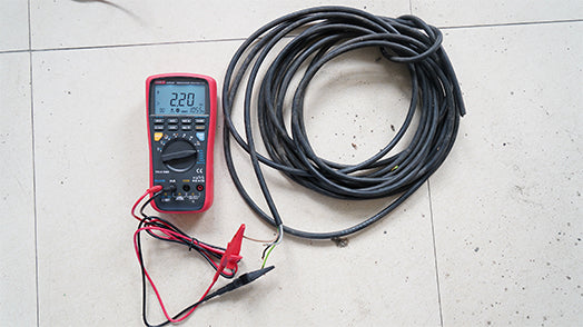 UNI-T UT533 Insulation Multimeter – Insulation Tester + Digital Multimeter - a red handheld device with a black dial and display reading 2.20, connected to a coiled black cable.