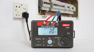 UNI-T UT582+ RCD / ELCB Tester – Digital RCD / ELCB Trip Tester - with three colored test leads connected, showing a digital display reading 20ms and 30mA next to a wall power outlet.