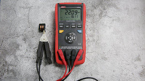 UNI-T UT612 Digital LCR Meter – 20000 Count, 100Hz–100kHz, L/C/R/DCR/Q/D/θ/ESR, Series/Parallel, Auto Range, USB, SMD Test Clamp, Handheld Bridge - with a red and black handheld body, displaying 22.09 mH and 16.11, connected to an SMD test clamp holding a small component.