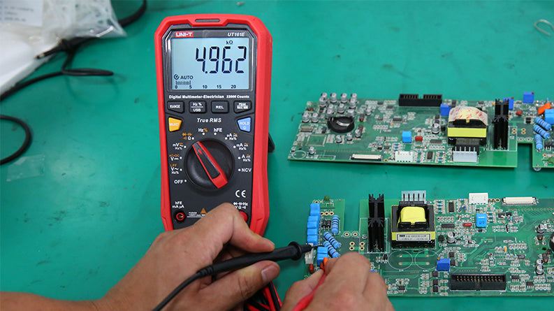 UNI-T UT61B+ True RMS Digital Multimeter – 6000 Count, AC/DC 1000V, 10A, Capacitance, Frequency, Temperature, NCV, USB, CAT III 1000V / CAT IV 600V - with a red casing, showing a 4.962 kΩ reading on its display while being used to test a green circuit board.