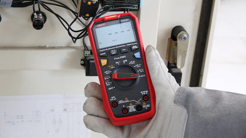 UNI-T UT61E+ True RMS Digital Multimeter – 22000 Count, AC/DC 1000V, 20A, High Accuracy 0.05%, 220MHz Frequency, Temperature, NCV, USB, CAT III 1000V - held in a gloved hand, showing a red casing, central rotary dial, input ports, and an NCV indicator on the display.