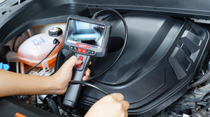 UNI-T UT663B 360° Rotatable Industrial Borescope – 5.0" HD Screen, 1920×1080 Photo/Video, 8mm Lens, 1 m Articulating Probe, IP67, 32GB, Inspection Camera - a live view of an engine component on its screen and a black camera probe inserted into a car.