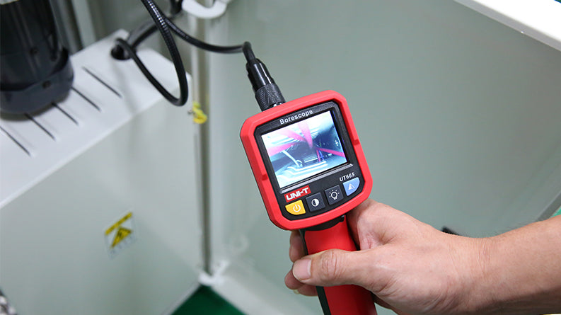 UNI-T UT665 Industrial Borescope – 2.4" TFT Screen, 9mm Camera Probe, 1m Semi-Rigid, IP67, 4 LED, Inspection Endoscope Camera - held in a hand, featuring a red handle, a 2.4-inch screen displaying a live inspection view, and control buttons.