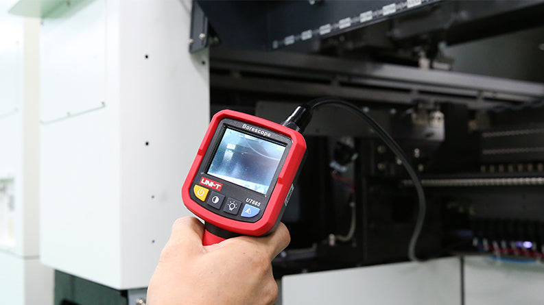 UNI-T UT665 Industrial Borescope – 2.4" TFT Screen, 9mm Camera Probe, 1m Semi-Rigid, IP67, 4 LED, Inspection Endoscope Camera - held in a hand, showing a red handheld device with a 2.4" screen displaying a dark view from its camera probe.
