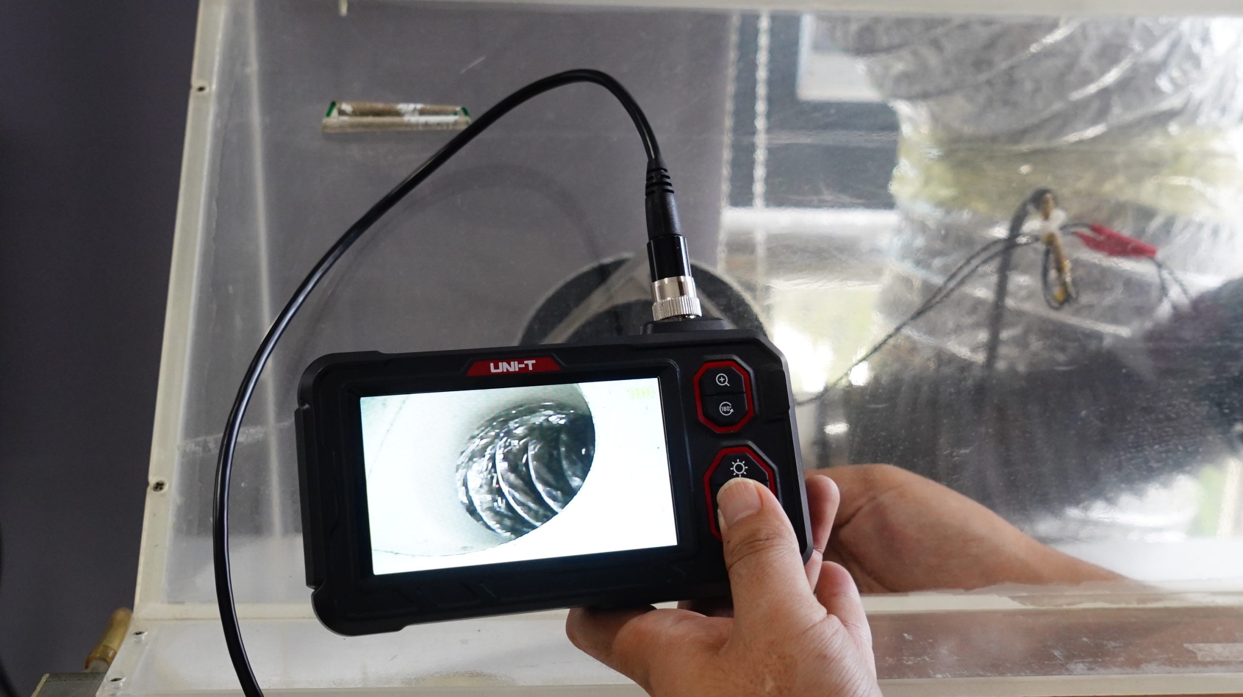UNI-T UT667-10M Industrial Borescope – 4.3" IPS Screen, 8mm Lens, 10 m Replaceable Probe, IP67, 8 LED, Inspection Endoscope Camera - a live view of a pipe interior on its 4.3-inch screen with visible control buttons.