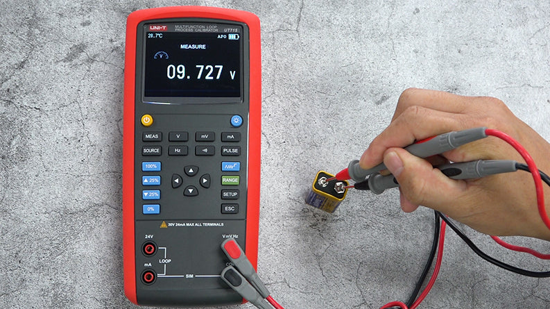UNI-T UT715 Multifunction Loop Process Calibrator – 24mA / 24V DC, Frequency, Pulse, 24V Loop Power, 20000 Count - with a red and black casing, showing a voltage measurement of 09.727 V on its screen while testing a battery.